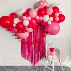 balloons and streamers are arranged in the shape of heart - shaped shapes on a wall