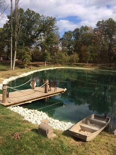 a small boat tied to a dock in the middle of a body of water with rocks around it