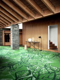 an empty room with green carpet and wooden walls