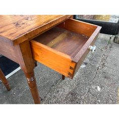 an old wooden desk with drawers on the bottom and one drawer open to show what's inside