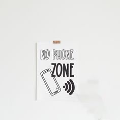 a sign that says no phone zone on the side of a wall with an image of a cellphone