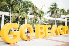 a woman sitting in front of the word go beach