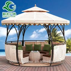 an outdoor gazebo with green cushions and pillows