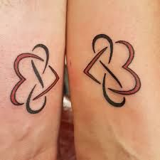 two tattoos on the legs of people with red and black lines in between them that are intertwined