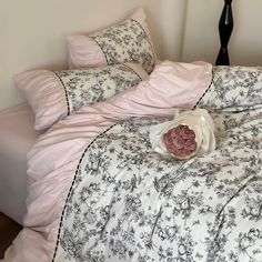 an unmade bed with pink and black comforters