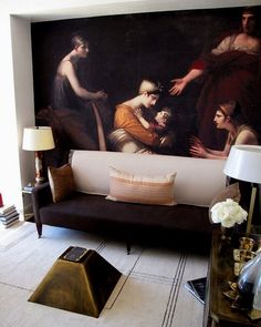 a living room filled with furniture and a large painting on the wall above it's couch