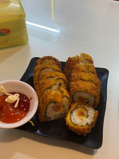 some food is laying out on a plate with sauce and ketchup in a bowl