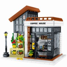 a lego model of a coffee house with potted plants on the front and side