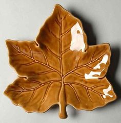 a brown leaf shaped dish sitting on top of a table