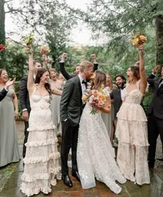 a group of people standing next to each other in front of trees and holding flowers