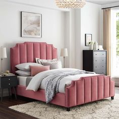 a pink bed with white sheets and pillows in a bedroom next to a large window