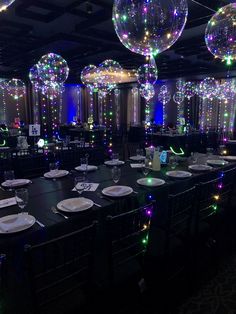 a table set up for a party with balloons and plates on the tables in front of them