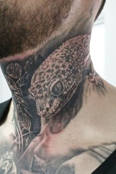 a man with a tattoo on his neck has an image of a lizard and flowers