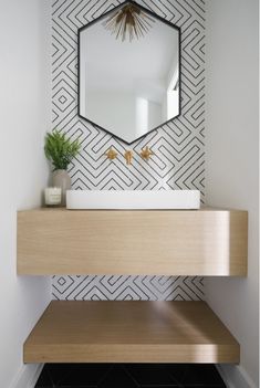 a bathroom sink with a mirror above it and a plant on the counter top next to it