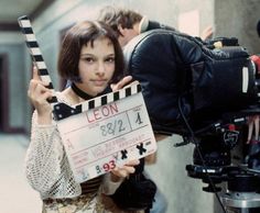 a woman holding up a clapper in front of a camera