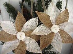 two burlocked flowers are hanging from the side of a wooden fence with pine needles