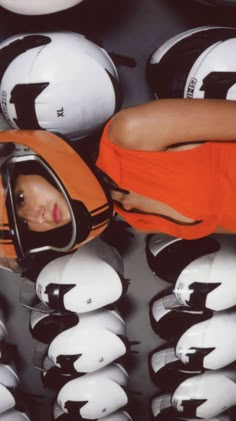 a woman in an orange shirt is looking into a helmet