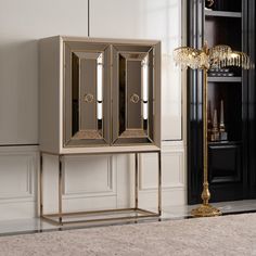 a gold and black cabinet in a room with a chandelier on the wall