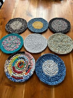 many different colored plates on a wooden table