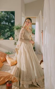 a woman in a wedding dress standing on a bed