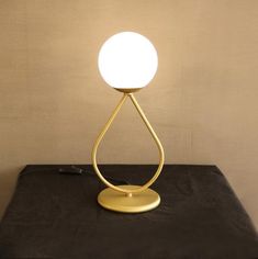 a table lamp sitting on top of a black table next to a white light bulb