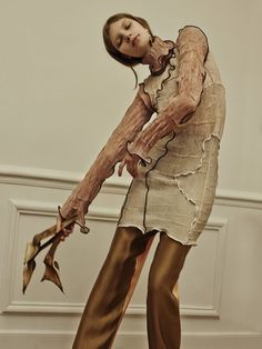 a woman is dressed up as a zombie holding a dead flower in her hand and posing for the camera