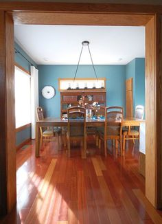 a dining room with hard wood floors and blue walls