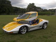 a yellow and white sports car parked in the grass