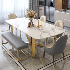 a white marble dining table surrounded by grey chairs with gold trim around the legs and backrests