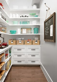 an organized pantry with white shelves and drawers