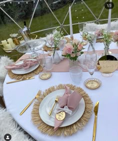 the table is set with pink and gold place settings