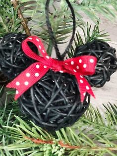 a mickey mouse ornament hanging from a christmas tree with a red bow on it