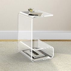 a clear table with a magazine holder on it's side and a cup in the middle