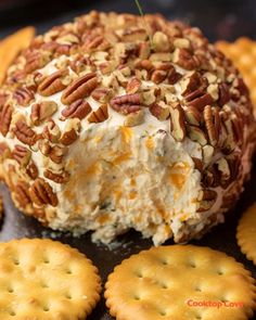 a cheese ball covered in pecans on top of crackers