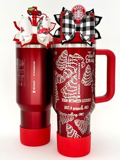 a red coffee mug with a bow on the top and another cup next to it