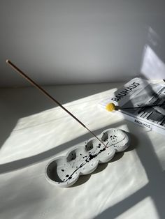 a pair of shoes sitting on top of a table next to a book and an incense stick