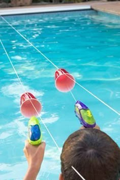 two people are playing in the pool with floaties on their heads and one person is pointing at them