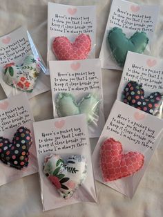 six heart shaped brooches are displayed on a sheet with words written in them