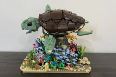 a lego turtle is sitting in the middle of some corals and other marine life