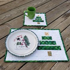 two placemats with green and white designs on them