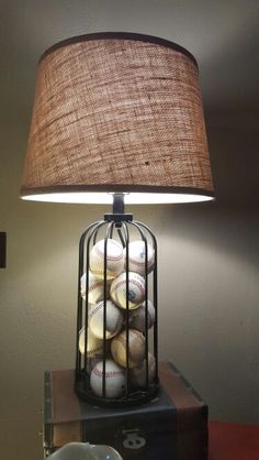 a lamp that is sitting on top of a table with baseballs in a cage