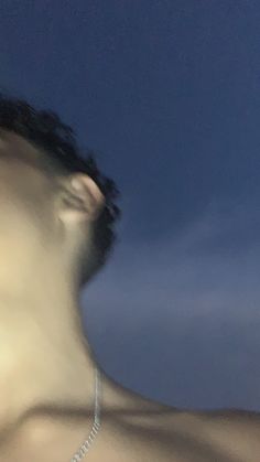 a blurry image of a man with no shirt on and his face partially obscured by the sky