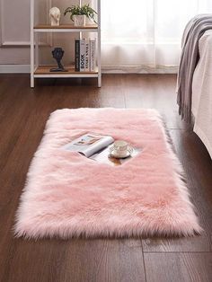 a fluffy pink rug on the floor in a bedroom