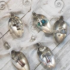 four silver spoons with charms hanging from them