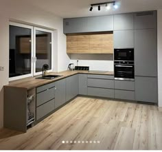 a kitchen with wooden floors and gray cabinets