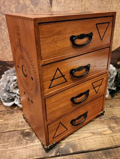 a wooden dresser with black handles and drawers on it's sides, sitting on a wood floor