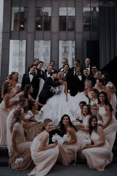 a large group of people in formal wear posing for a photo on the steps outside an office building