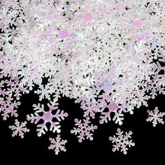 white snow flakes on a black background with pink and silver glitter in the middle