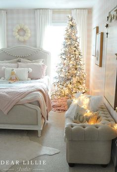 a bedroom decorated in pink and white with a christmas tree next to the bed,