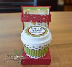 a cupcake box with a card in it sitting on top of a wooden table